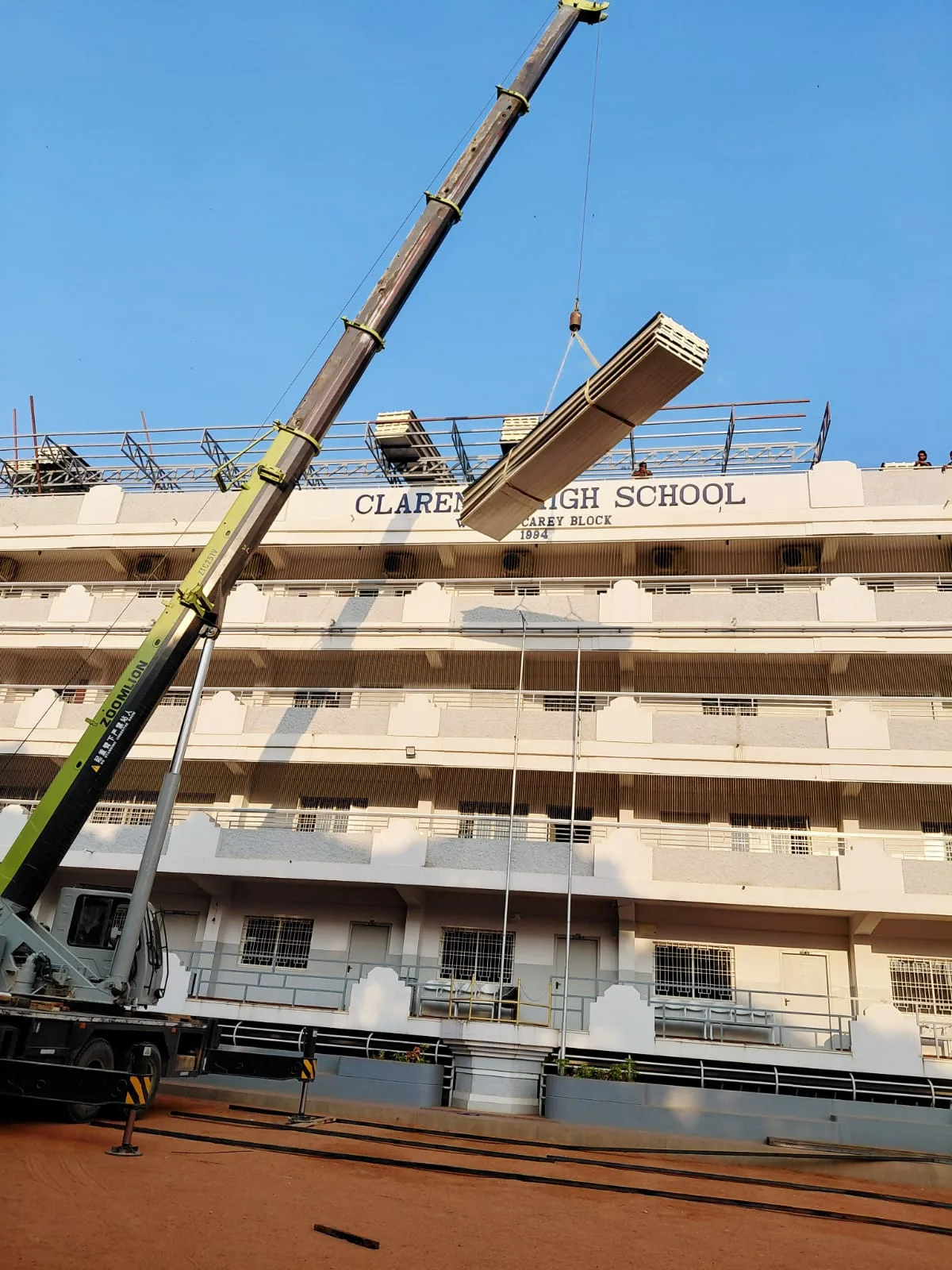 Crane lifting building materials beside a multi-storey building