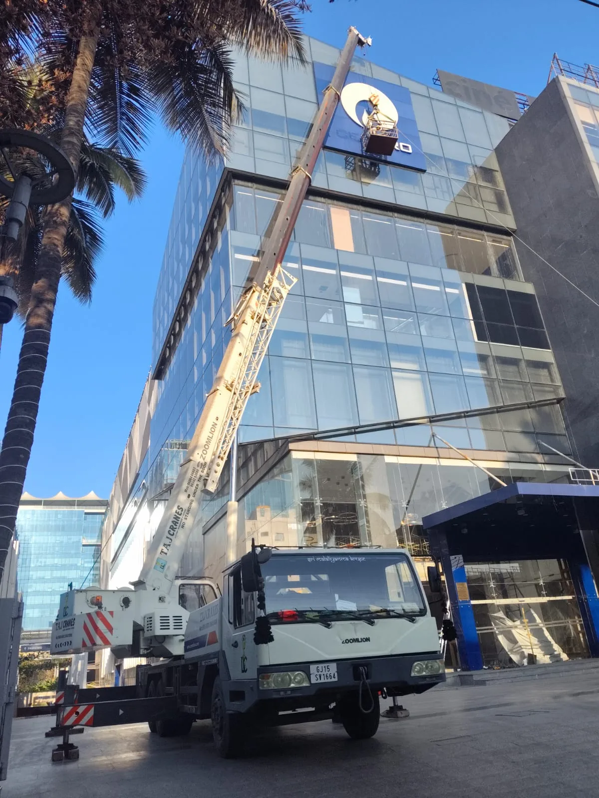 Mobile crane alongside a glass-fronted building