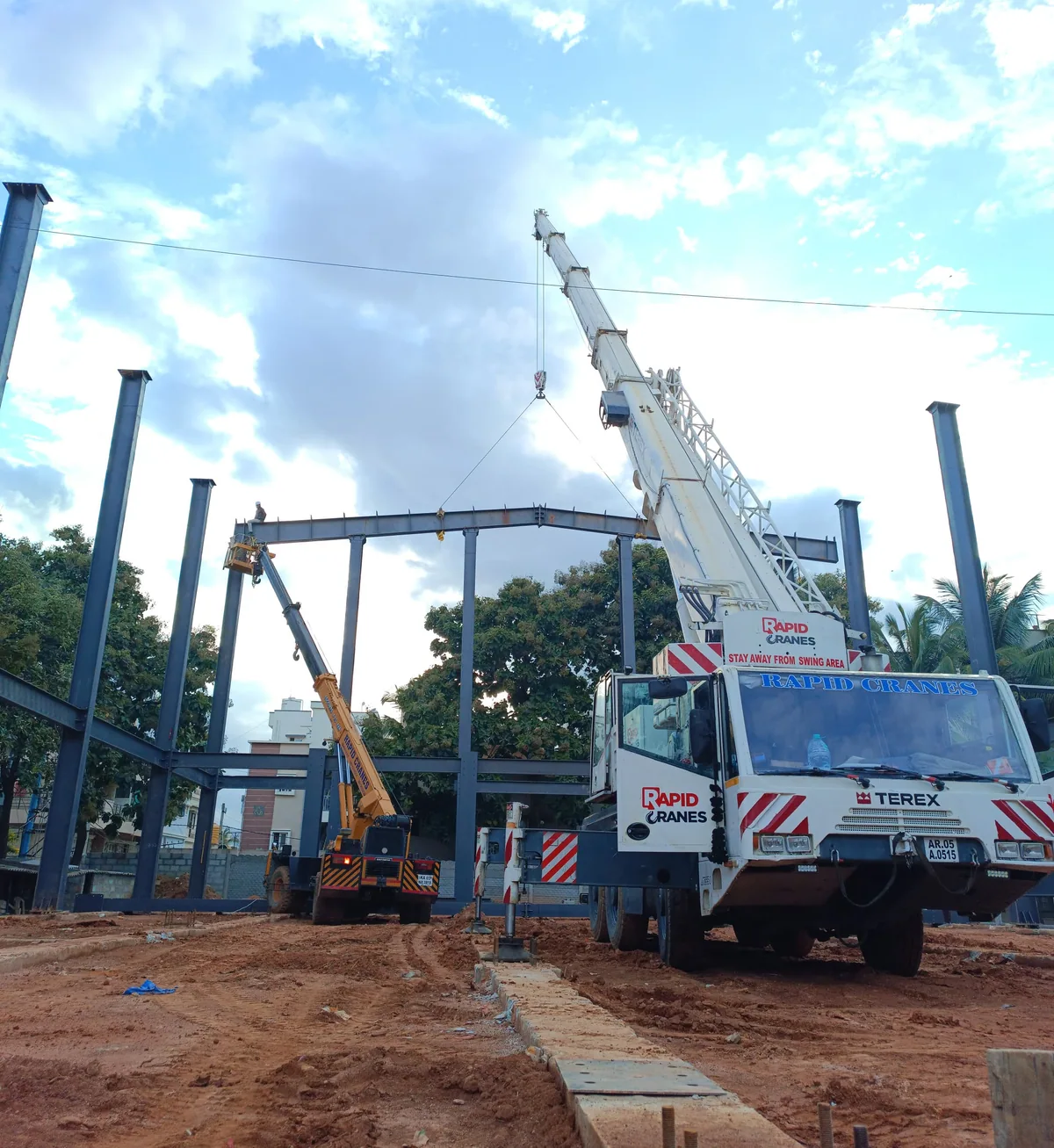 Rapid Cranes lifting a steel beam at a construction site